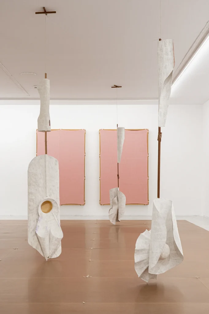 Instalación escultórica con telas blancas y elementos suspendidos